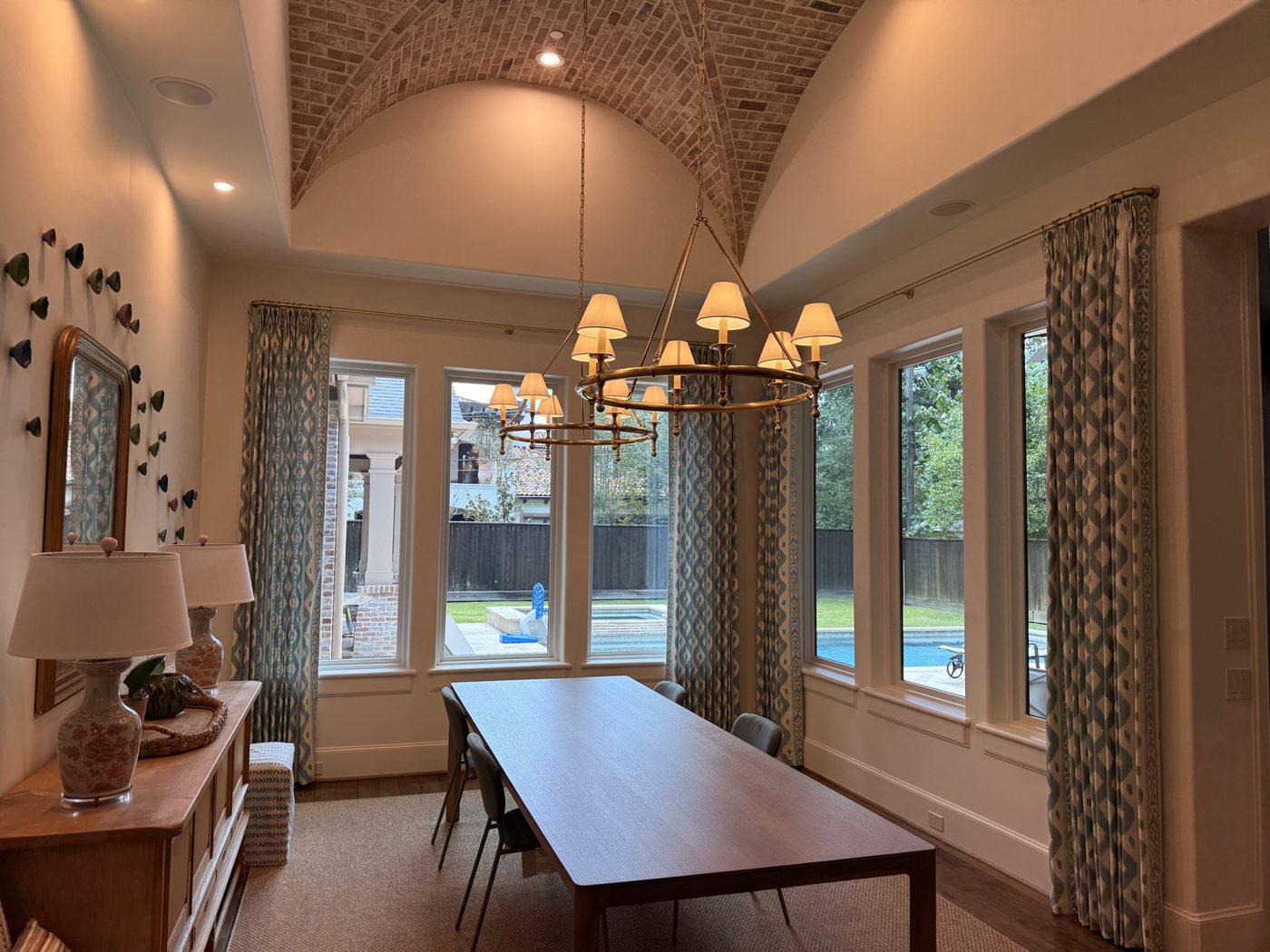 Patterned drapery panels on brass rods in a dining room