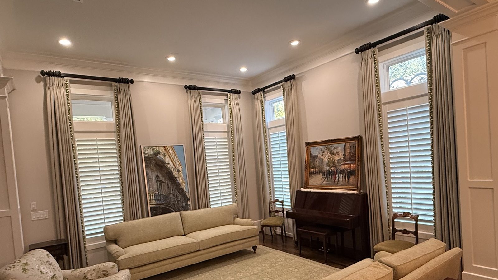 Cream drapery and white plantation shutters in a finished living room