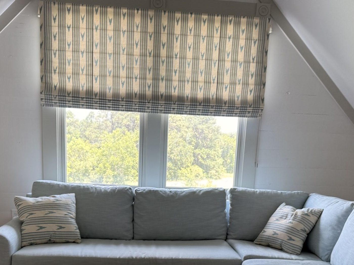 Patterned Roman shade lowered over a loft window