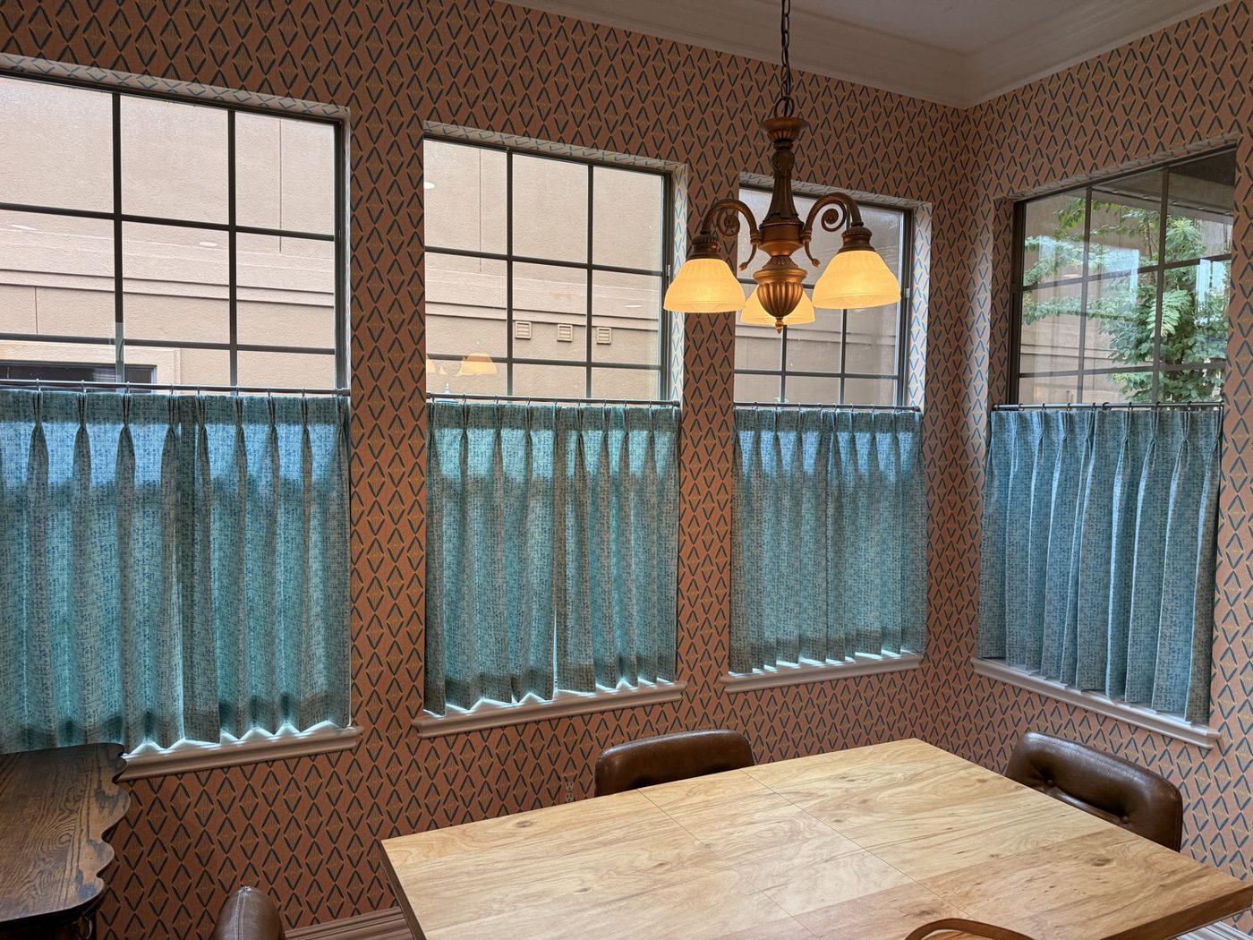 Teal cafe curtains in a dining nook